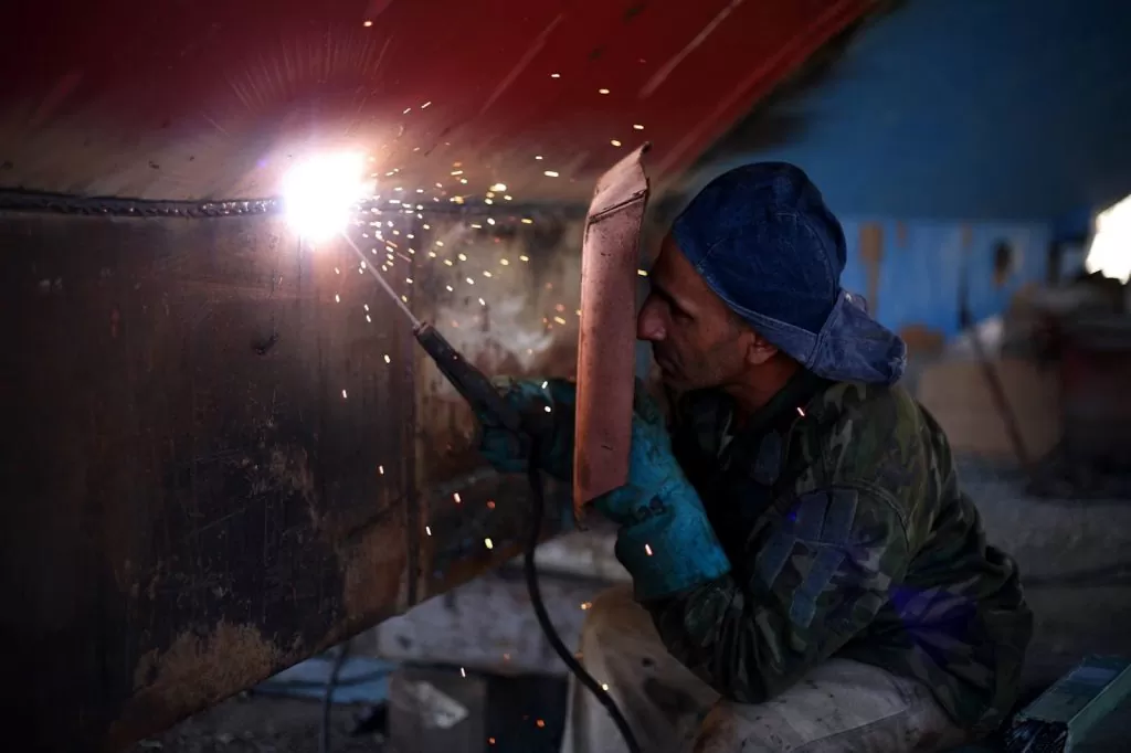 A worker welding a metal part