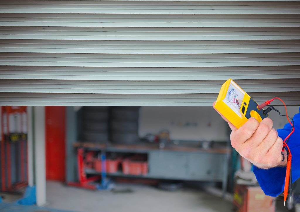 Hand with Tool in Front of the Garage