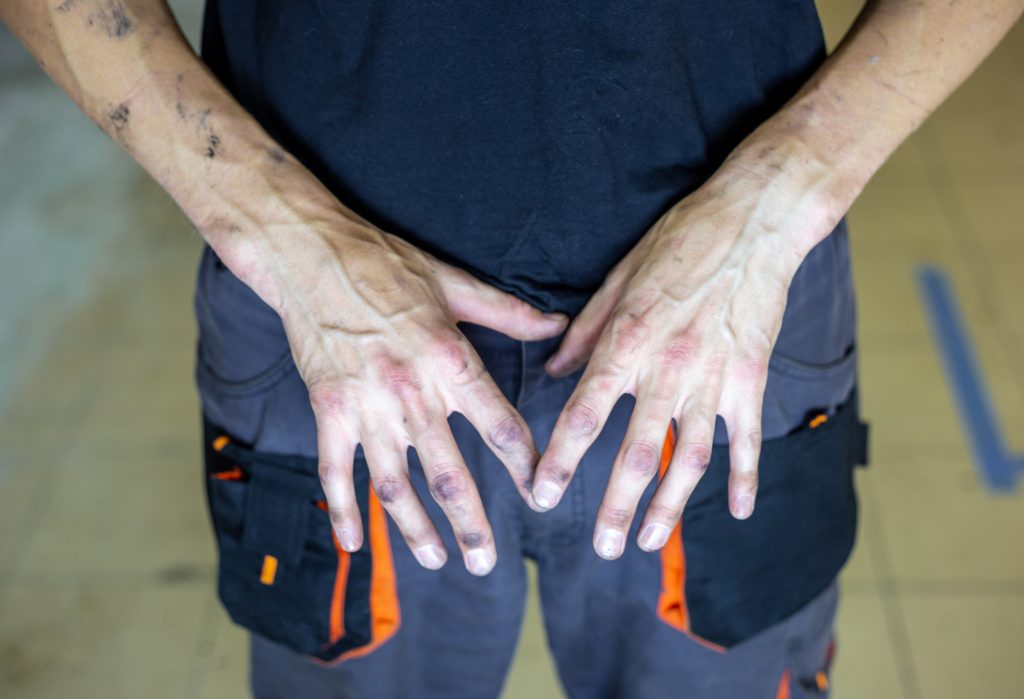 Hands of a mechanic full of grease after work